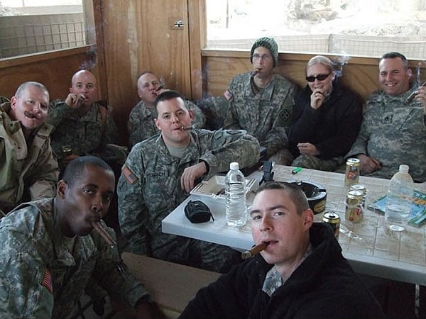 TF Wildcat Cigar Club members enjoy a recent CI order in the &rsquo;&rsquo;Smoke Shack Out Back&rsquo;&rsquo;. Clockwise from lower left: 1LT Loniel Greene, MAJ Clarence (Mike) Walton, CSM Michael Boyd, LTC Stephen Strand, MAJ Richard Wells, 1LT Joleen Joles, SSG Nick Abbott, 1LT Shawn Woodside. Center: SGT Matt Henrich.