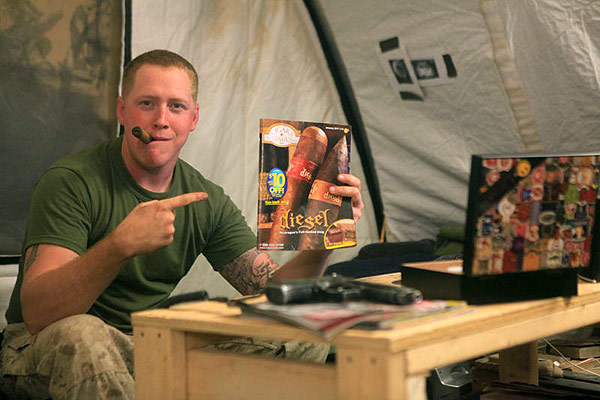 Sgt Taylor at his table with a CI Cigar Band humidor and the CI Catalog. "There are very few things that are both relaxing and enjoyable while serving in Afghanistan. But a tasty cigar after every patrol tops the chart."