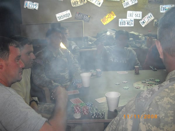 Some soldiers playing poker and enjoying some cigars at the Mudhouse in Iraq