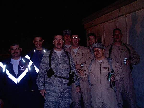 LtCol-select Bull Murphy (center/front) enjoys a cigar in celebration of promotion board results along with (left to right) Maj Ruben Garza, Maj Franklin Espinal, LtCol Devin Donnelly, Capt Cujo Cuomo,  MSgt David Boggs, TSgt Scanman LeClaire, and TSgt Bear Davenport. All members of CSTC-A Command Surgeon&rsquo;s Office in Afghanistan.