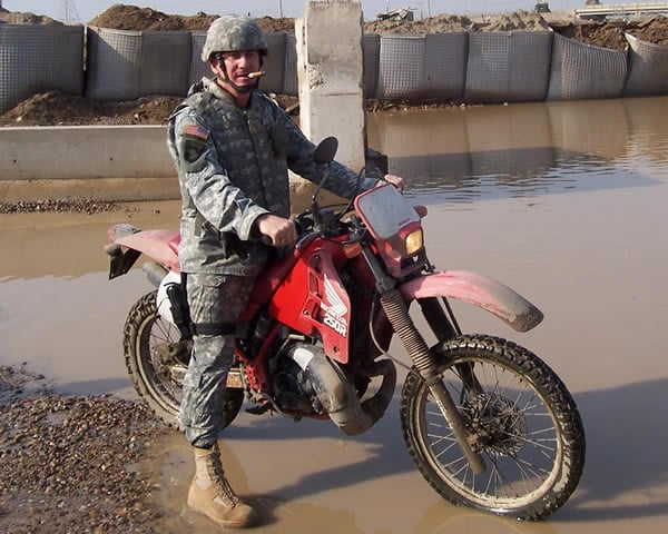 Major Mike Goyne, stationed in Iraq, enjoying a cigar and a ride on a motorcycle.