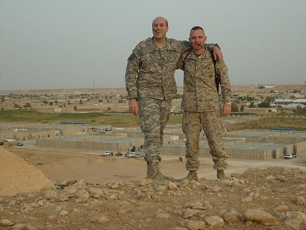 CPT Papka and MAJ Milne smoking CI cigars on the cliffside overlooking an airbase, Iraq. CPT Papka is with the 1st Brigade, 82nd Airborne and MAJ Milne is with the 2 Marine Expeditionary Force.